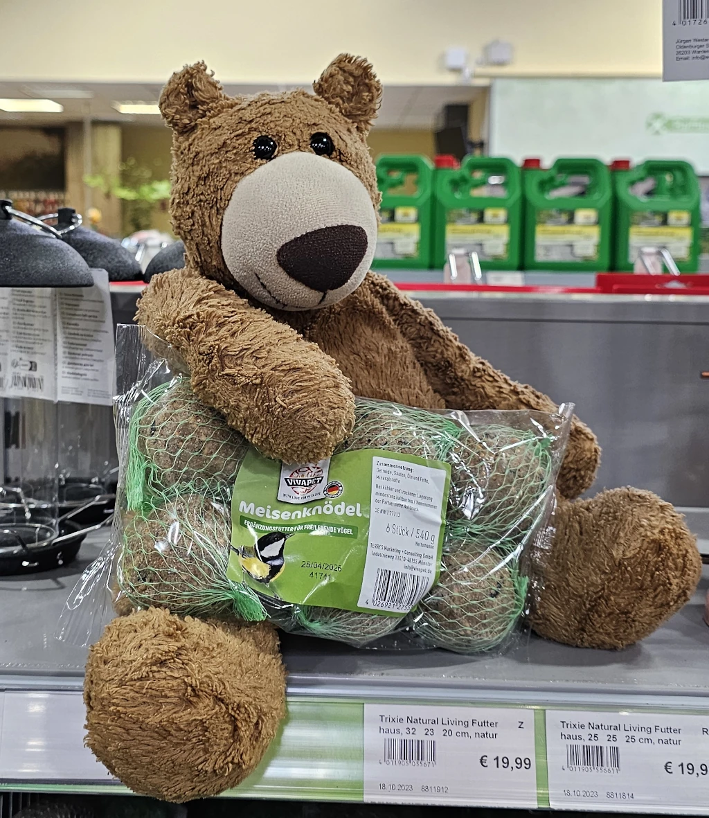 ein Bär häält eine Packung Meisenknödel fest